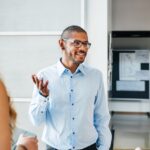 A business leader talking to two other employees.