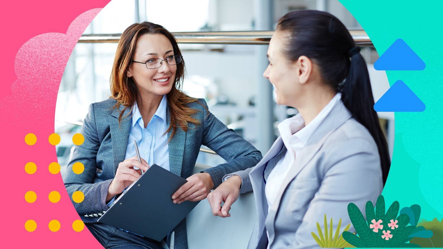 Two businesswomen in a modern office setting engage in a discussion, representing sales management training.