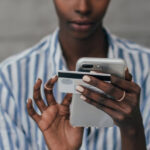 woman holding both her smartphone and credit card: digital process automation