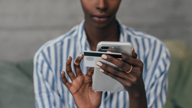 woman holding both her smartphone and credit card: digital process automation