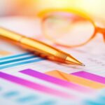 Glasses, pen and paper showing gross profit margin.