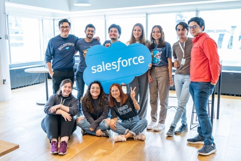 Futureforce interns in Salesforce sweaters hold a giant Salesforce logo