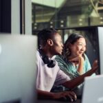 Two people at work looking at a computer screen.