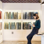 A woman sitting on a desk in front of a bookcase