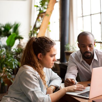 A man and woman looking at a laptop