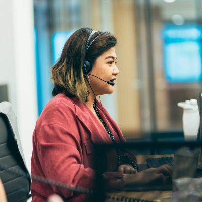 Customer service representative speaking into headset microphone.