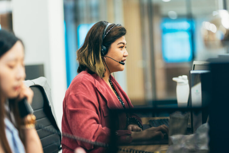 Customer service representative speaking into headset microphone.